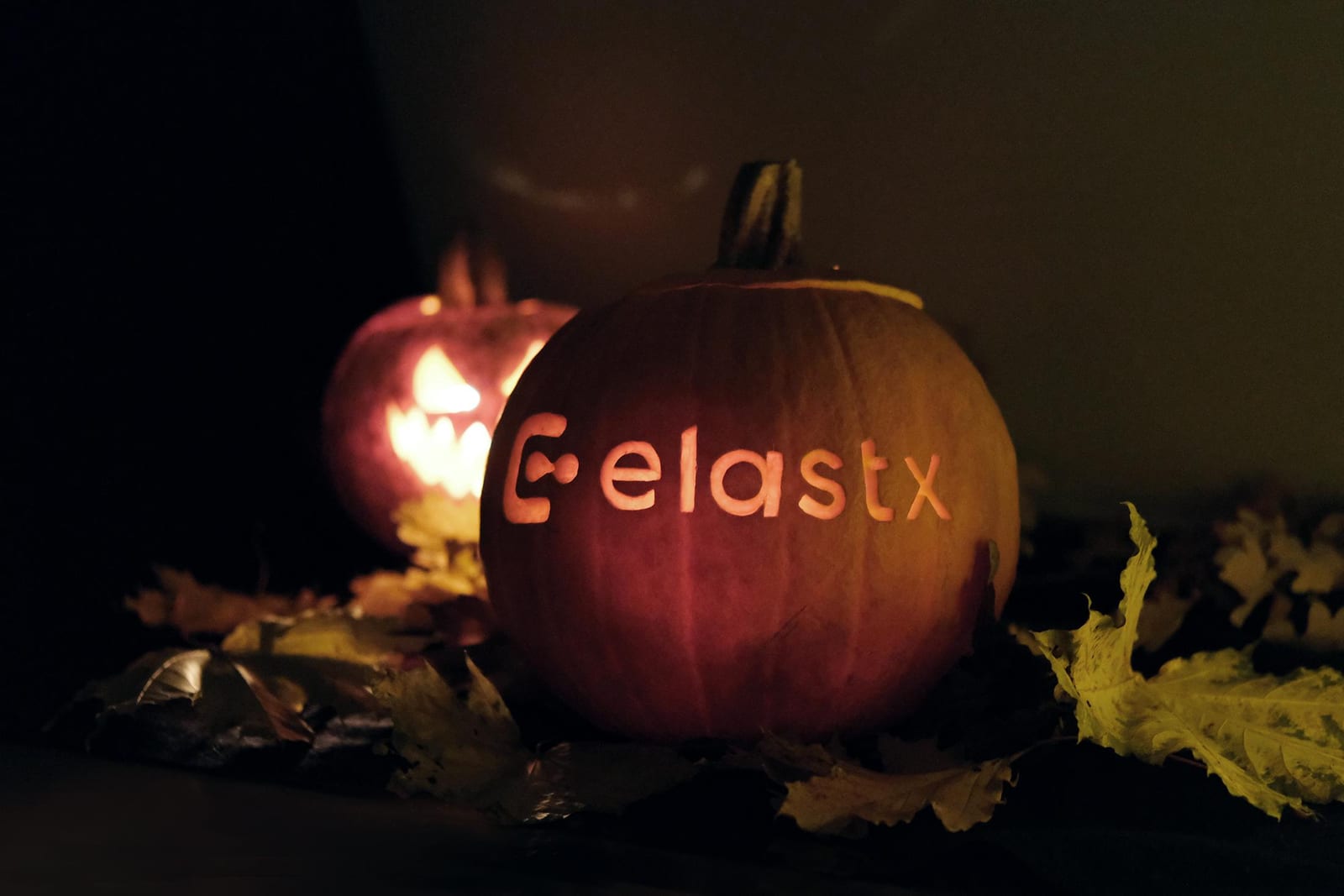 En pumpa med Elastx-logotypen framför en pumpa med ett grinande ansikte